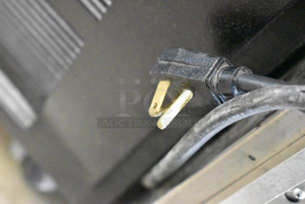 Close-up of a power plug and cable for True GDM-49 commercial cooler, highlighting electrical components.