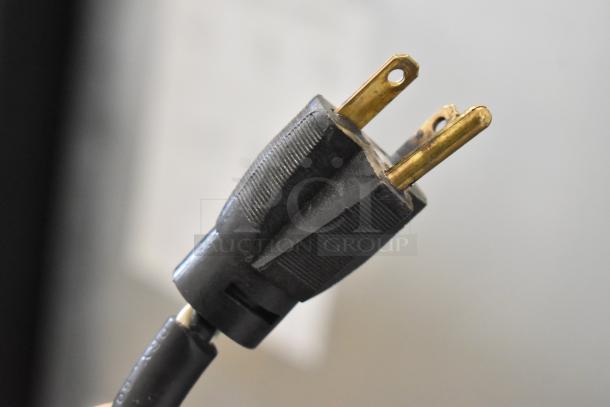 Close-up of a standard electrical plug, three prongs, connected to a Federal RSSL678SC merchandising unit, 208-240V, 1 phase.