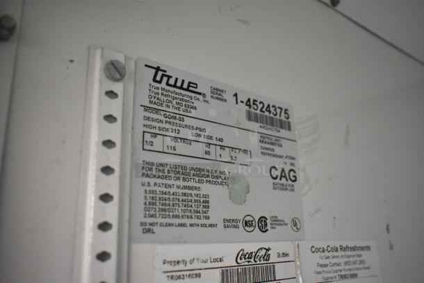 True GDM-33 metal cooler label with model info and care instructions, made in USA. Features voltage details and NSF, UL certifications.