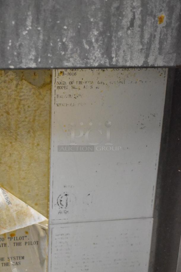 Cook Rite stainless steel commercial gas fryer on casters, weathered condition, labels indicating maintenance and model details.