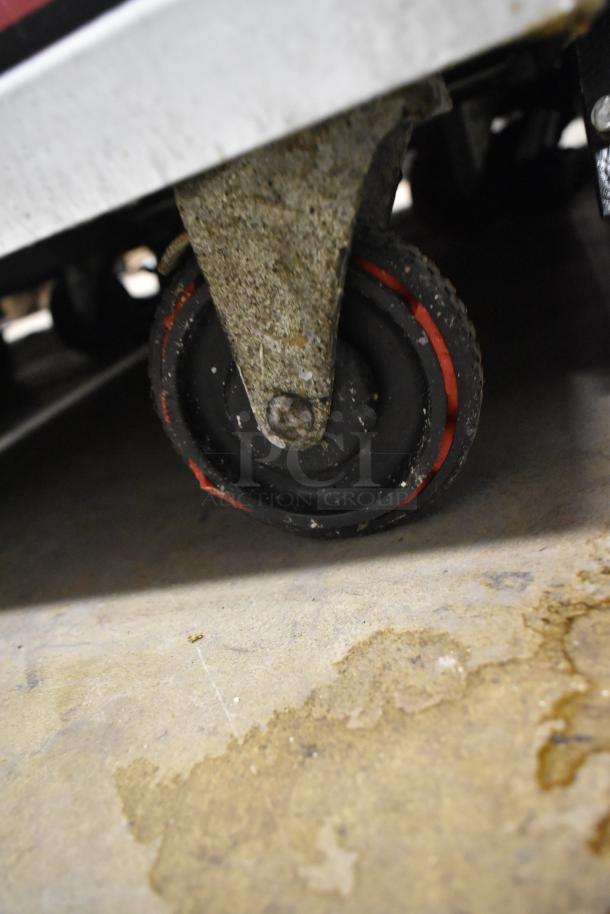 Win-holt metal commercial heated holding cabinet caster, showing signs of wear, suitable for easy maneuverability.