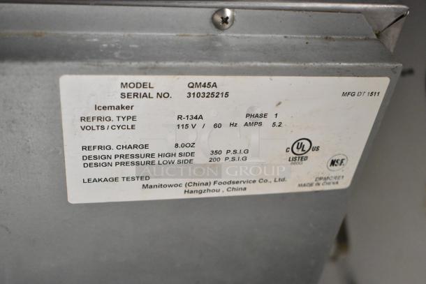 Manitowoc QM45A stainless steel ice machine label, showing model, voltage, refrigerant details, and certification marks.