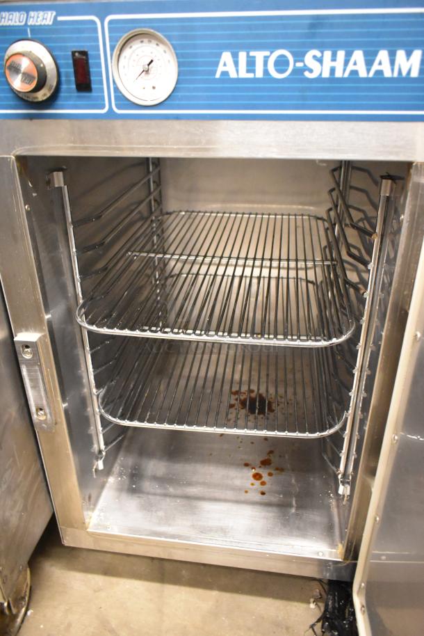 Alto Shaam 500-S stainless steel heated holding cabinet on casters, 125V, 1 phase, with open door showing shelves.