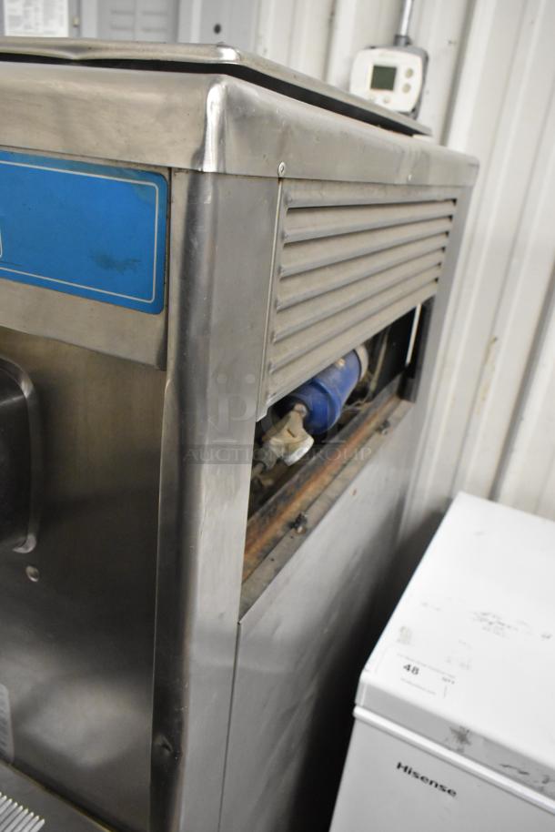 Taylor 754-27 stainless steel soft serve ice cream machine on casters, showing side panel detail, 2 flavor with twist, 208-230V, 1 phase.