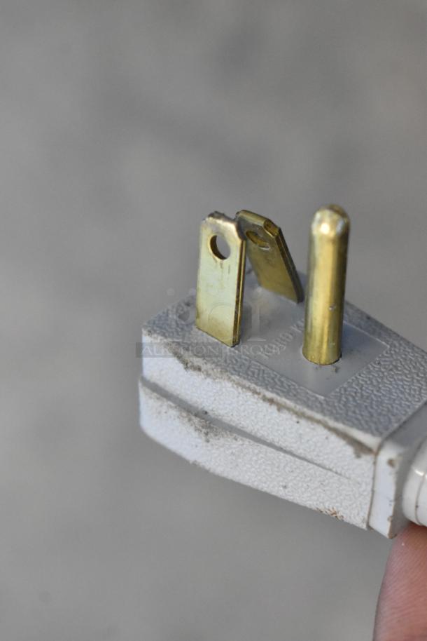 Close-up view of a standard three-prong electrical plug with visible signs of wear.