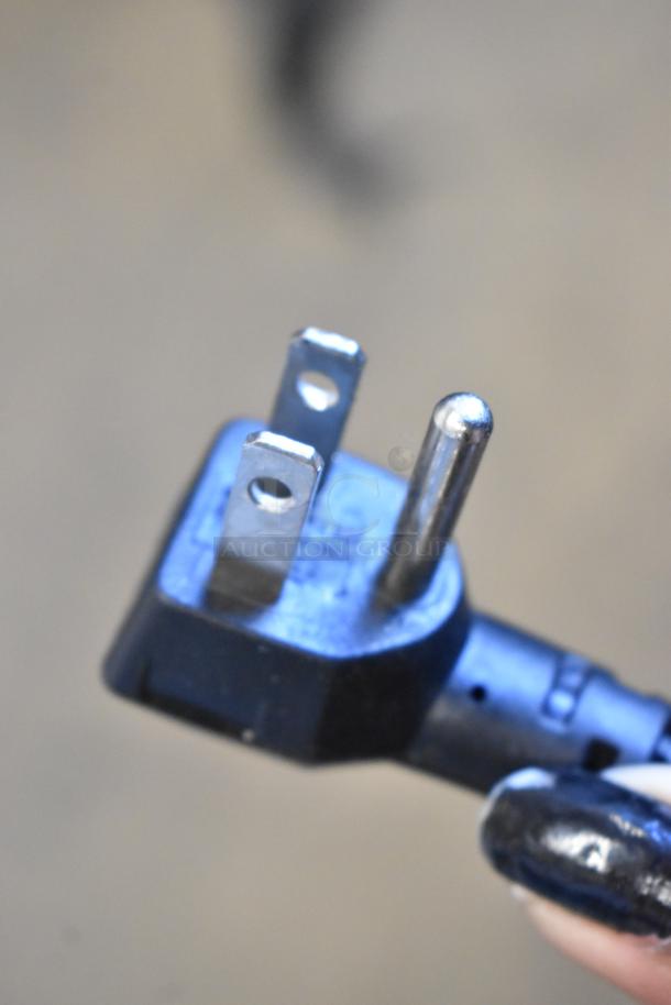Close-up of a three-prong plug connected to an Alto Shaam 750-S heated holding cabinet.