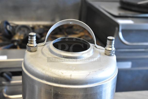 Three metal home brew kegs with handles, dual valves, visible wear, ideal for brewing enthusiasts.