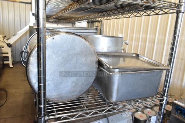 Metal stock pots and stainless steel drop-in bins on a metal shelving unit, in good condition.
