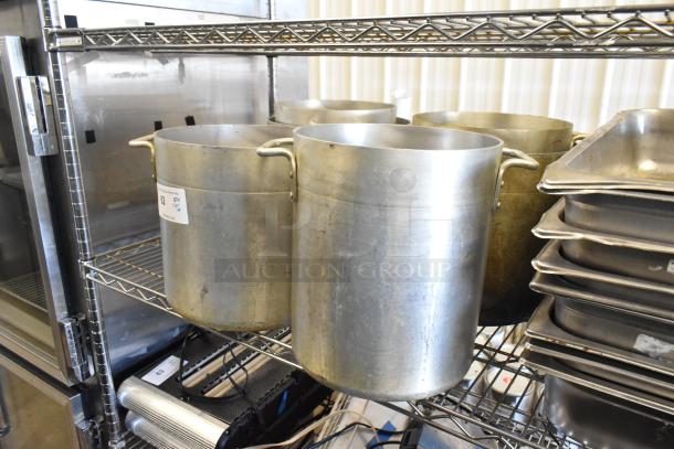 Metal stock pots and stainless steel drop-in bins on metal shelves, used condition. Label indicates Lot #62.