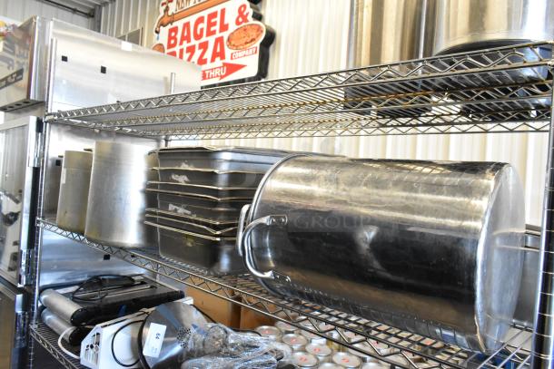 Metal stock pots and stainless steel drop-in bins on wire shelving. Includes various kitchen items, shows wear.
