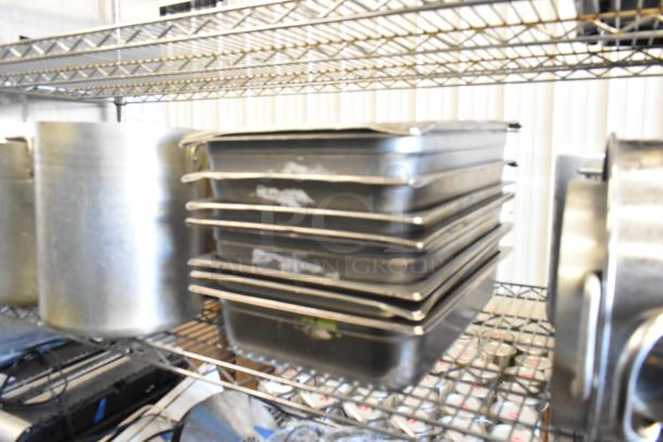 A tiered shelf with metal stock pots and stainless steel drop-in bins, various conditions.