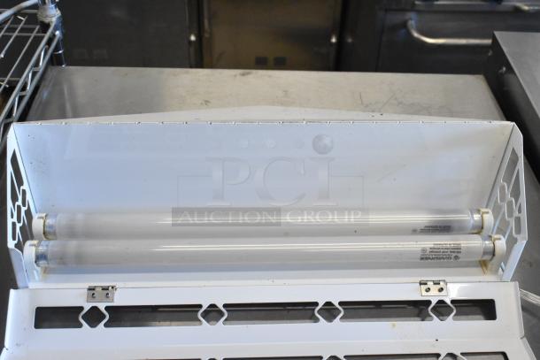 Bug zapper with two fluorescent tubes, white metal casing, minimal wear, visible branding by Gardiner, indoors setting.