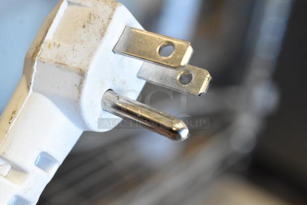 Close-up of a white electrical plug with metal prongs, slightly dirty, likely for auction items: Bug Zapper and Pelsis Light Fixture.