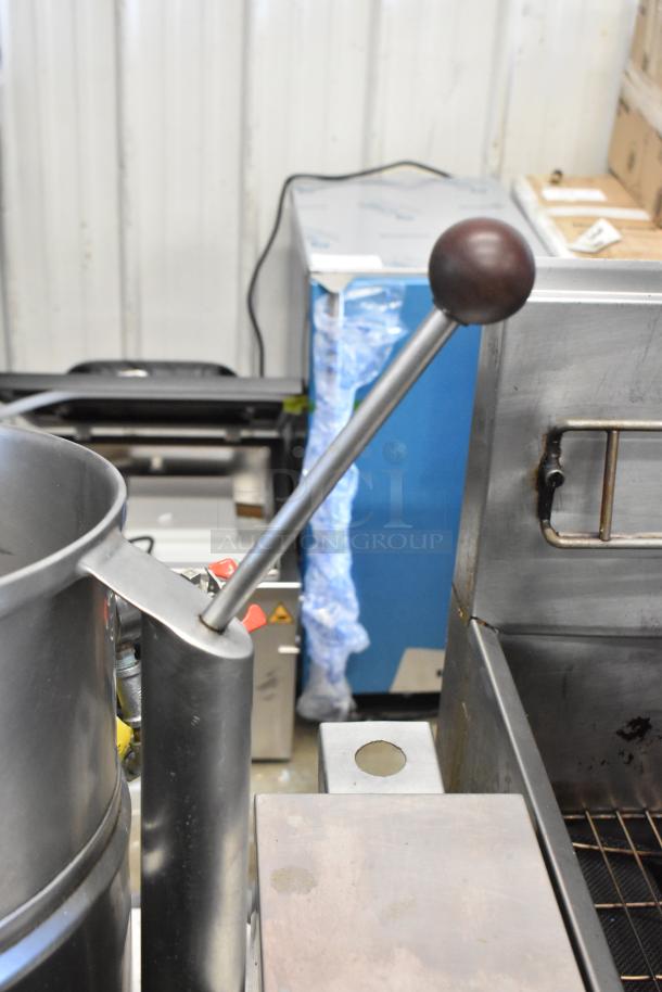 Groen stainless steel commercial electric steam kettle, lever detail shown. Electric powered, 208/240 volts.