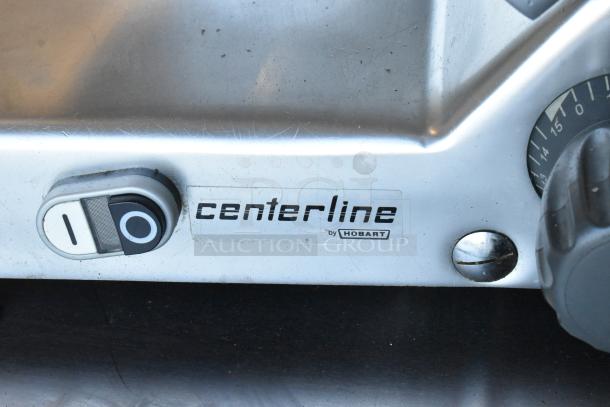 Stainless steel Hobart Centerline EDGE12-11 meat slicer with blade sharpener, 115V, 1 Phase, label reads "centerline by Hobart."