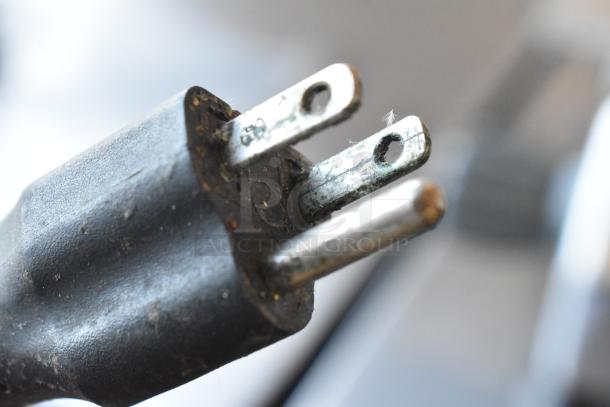 Close-up image of the plug on a Hobart Centerline EDGE12-11 commercial meat slicer, showing slight wear.