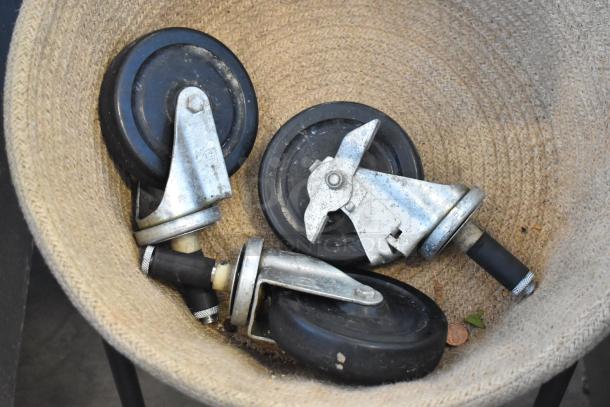 Basket with three commercial casters on metal stand, showing durable black rubber wheels and metal frames.