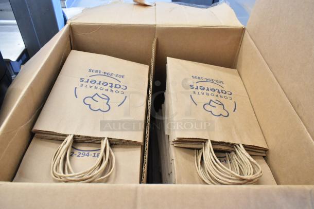 Box of paper bags with "Corporate Caterers" logo, handle detail, in good condition. Auction includes a rug.