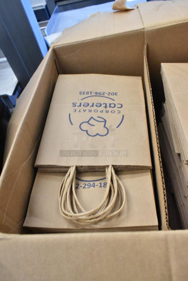 Box of paper bags featuring logo and contact number, part of auction lot with rug; "2 Times Your Bid" offer.