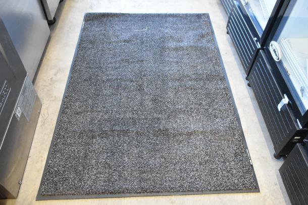 Gray floor rug, clean and textured, with black border. Auction includes box of paper bags; double your bid feature.
