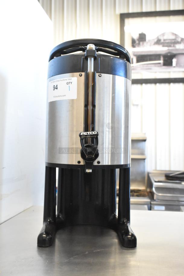 Fetco Stainless Steel Beverage Holder Dispenser, black and silver, with tap, in good condition, auction label visible.