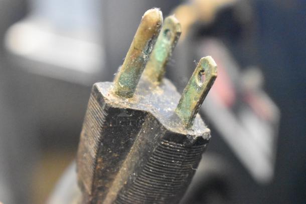 Close-up of a worn-out plug for Hatco CS2-10 Chef System S2, highlighting rust and wear on prongs.