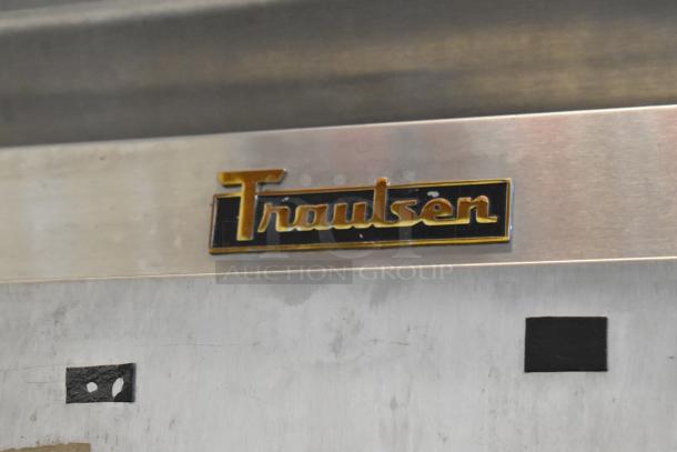Traulsen G12000 stainless steel reach-in freezer, logo detail. Features 2 half-size doors, metal racks, 115V, 1 phase.