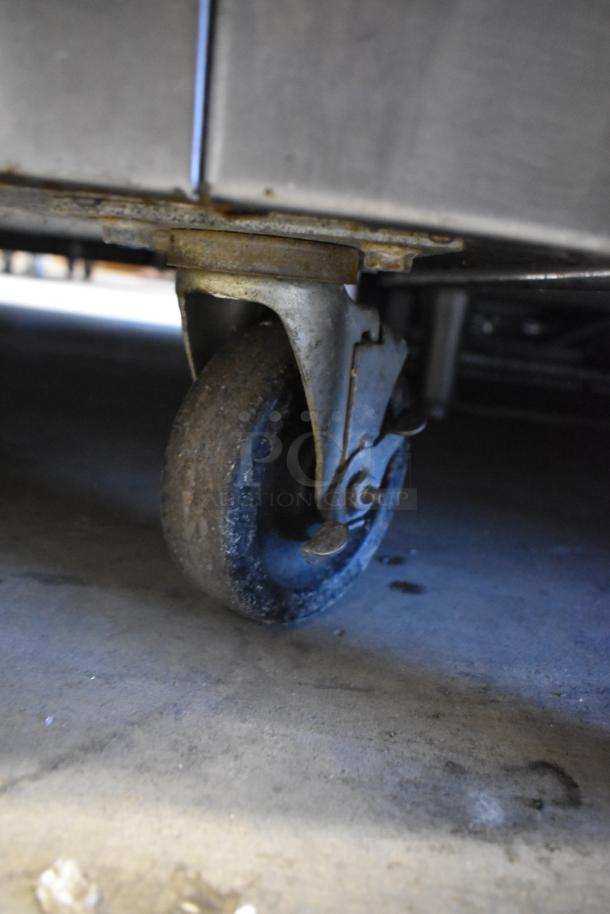 Commercial caster wheel of Traulsen RHT 2-32NUT Reach-In Cooler, showing wear conducive for easy movement.