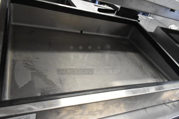Stainless steel ice bin with drainage hole, used condition, showing minor surface scratches and wear.