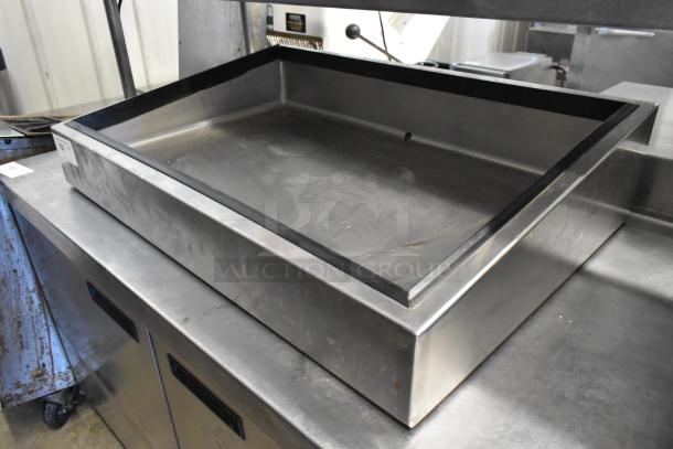 Stainless steel ice bin with polished finish, rectangular shape, slight wear, suited for commercial use.