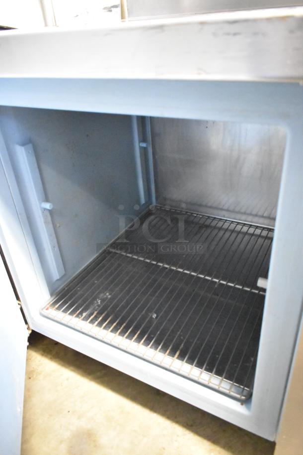 Delfield stainless steel commercial 3-door work top cooler with over shelf, interior view showing shelving and stainless steel finish. 115 volts, 1 phase.