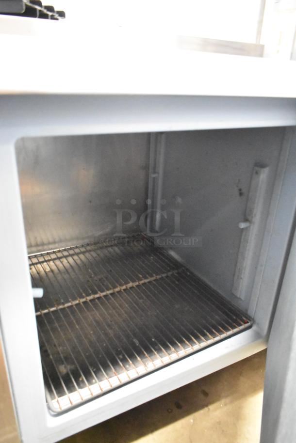 Delfield stainless steel 3-door work top cooler with over shelf; 115 volts, 1 phase, interior view showing condition.