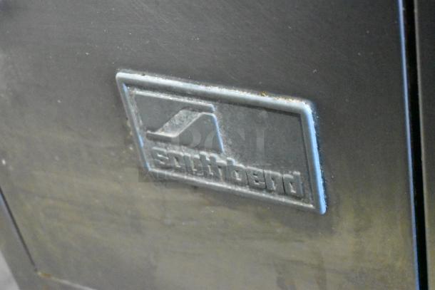 Southbend stainless steel commercial gas range with 2 burners, 2-tier overshelf, backsplash, and casters; brand logo visible.