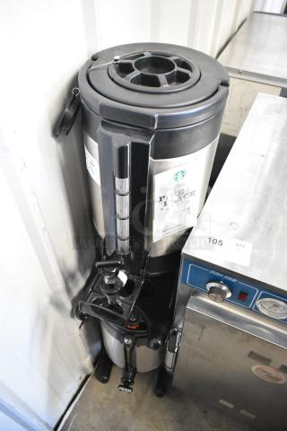 Stainless steel beverage holder dispenser with black lid and tap, featuring a "Pike Place" coffee label.