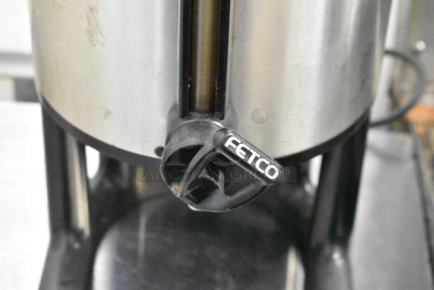 Stainless steel Fetco beverage dispenser with visible spout, in used condition. Ideal for auctions, multipack offer.