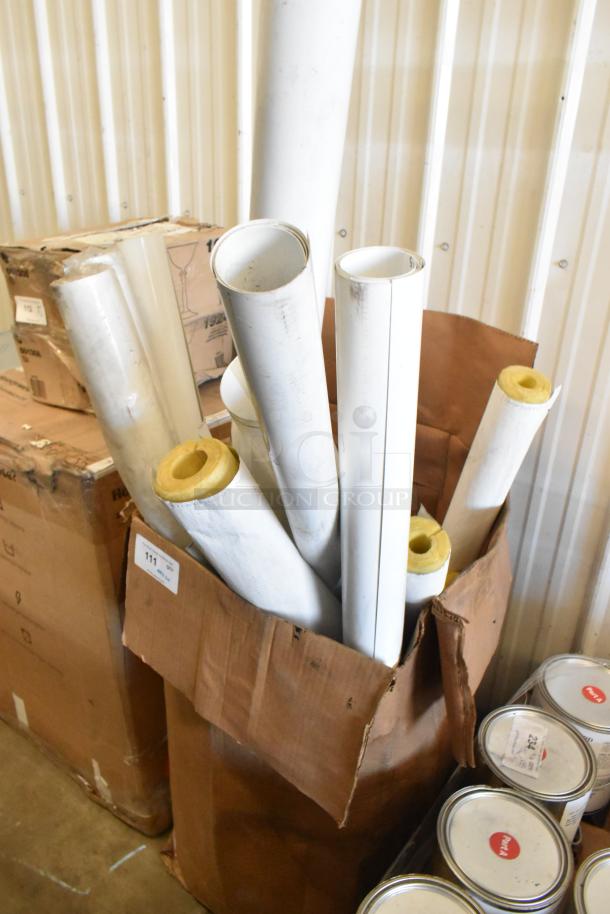 Assorted white tubes in a cardboard box, varying lengths, with some insulation visible. Auction items, 20 tubes total.