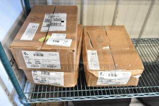 3 sealed boxes of Zebra labels, each containing 6 rolls of 1,240 labels, on a metal shelf. Labels visible on boxes.