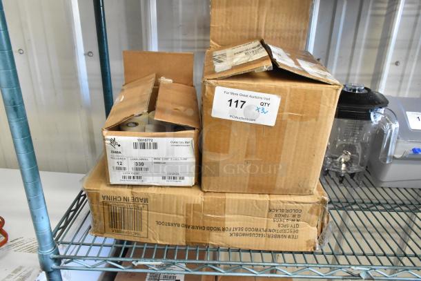 Three boxes containing 6 rolls of 1,240 Zebra labels, 164CUSHWDBLK cushions, and a phone set on a storage rack. Labels on boxes indicate product details and auction lot number. Boxes show wear.