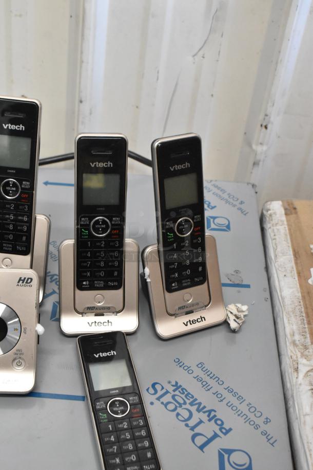 VTech phone set with multiple handsets, charging bases, and clear buttons displayed on a table.
