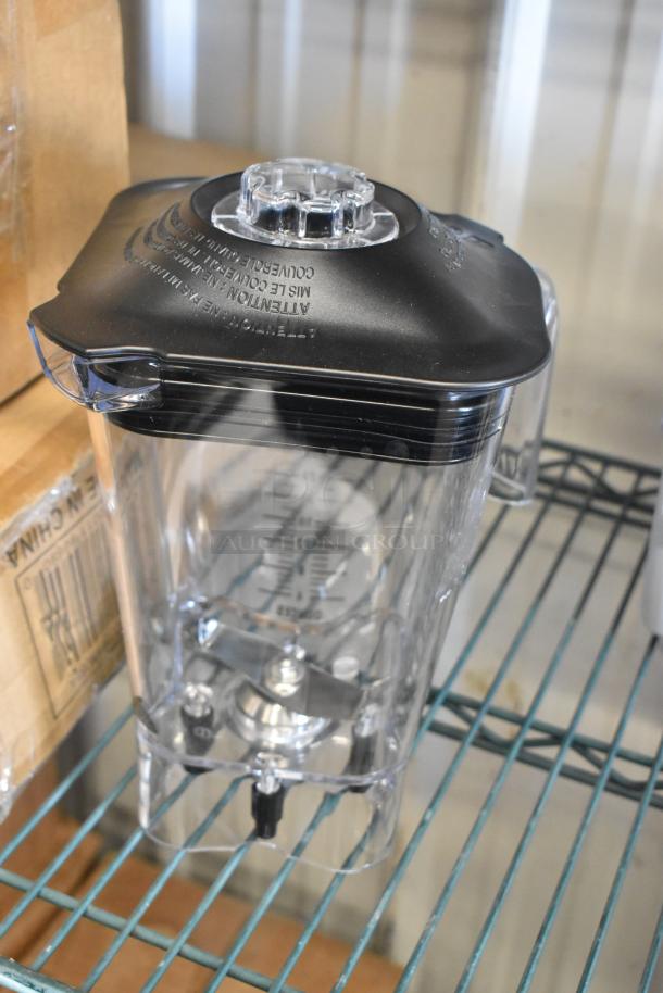 Blender pitcher with black lid, clear markings visible, in excellent condition. Includes TableCraft paper product roll dispenser.