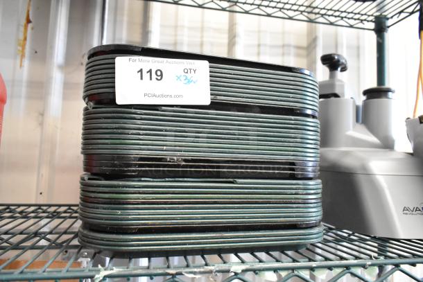 Stack of 36 poly food trays on a metal shelf, each tray in used condition. Auction label with quantity noted as x36.