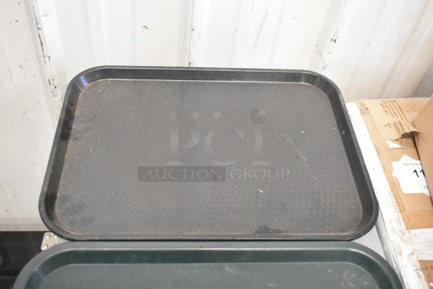 Set of 36 black poly food trays, lightly used, visible scuff marks, perfect for restaurant or catering use.