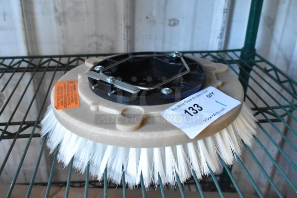Brand new floor cleaning brush with white bristles, minor scratches, and dents. Includes product warning label. Auction tag attached.