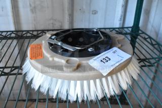 Brand new floor cleaning brush with white bristles, minor scratches, and dents. Includes product warning label. Auction tag attached.