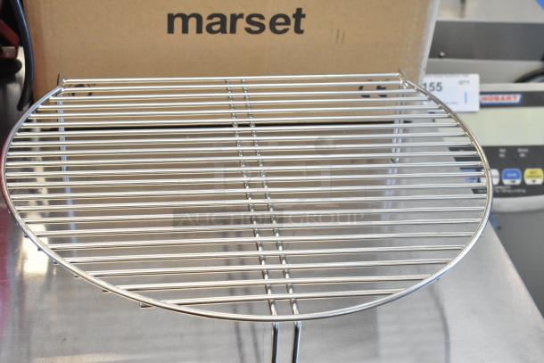 Round wire rack on stainless steel surface, part of Nordic Ware Naturals set, in new condition. Cardboard box in background.