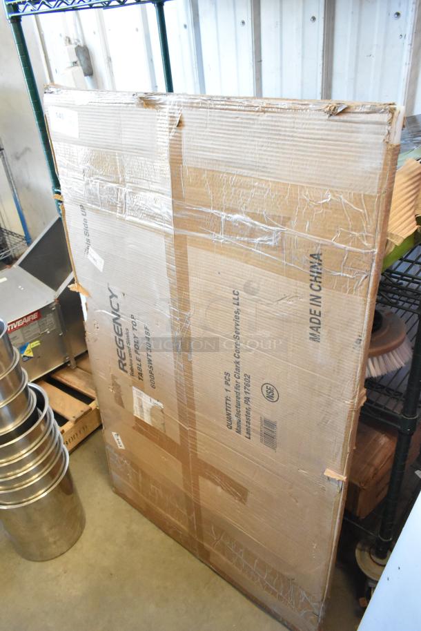 Cardboard packaging showing Regency 30" x 48" poly table top label and markings. Item new with scratch and dent notices.