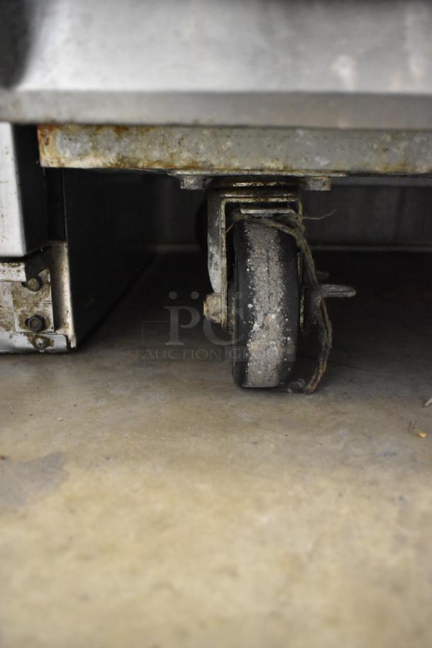 Avantco 178A49FHC freezer caster wheel, showing wear, on industrial floor.