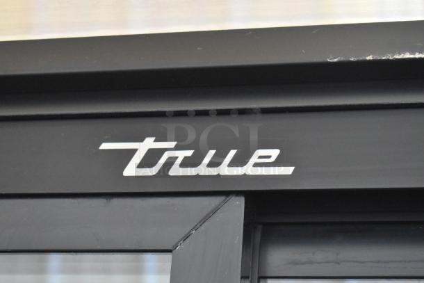 2019 True GDM-33-HC-LD cooler logo detail. Black metal frame with white "True" branding.