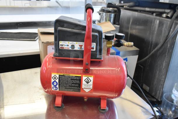 Central Pneumatic 3-gallon air compressor, 100 PSI, 1/3 HP, 115V, 1 phase. Red tank, black handle, visible gauges and warning labels.