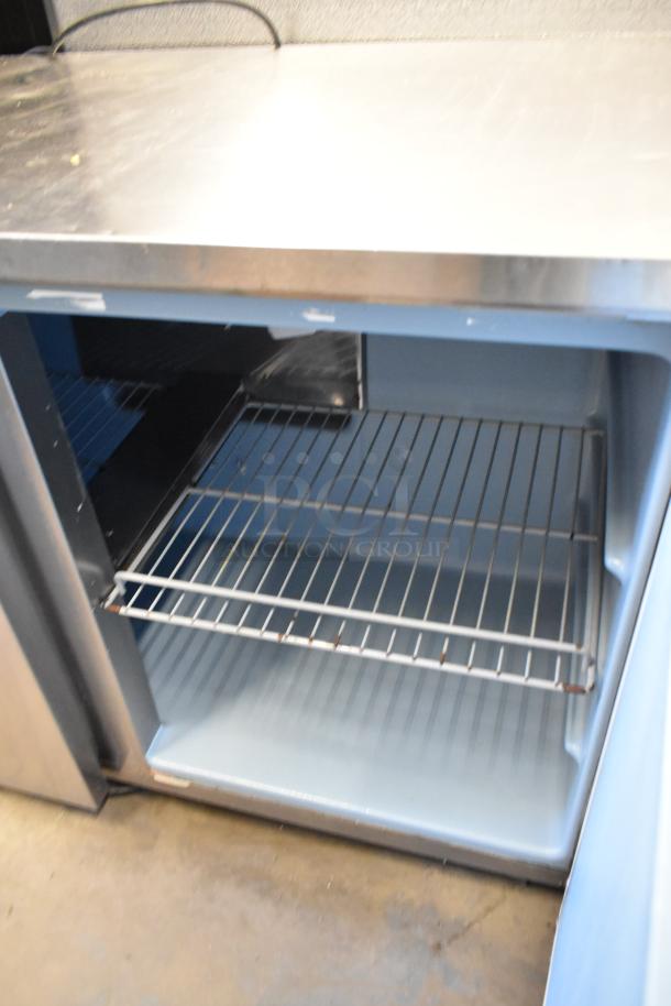 Delfield stainless steel undercounter cooler, two doors, on casters, 115V, 1-phase, features wire shelves, clean interior.